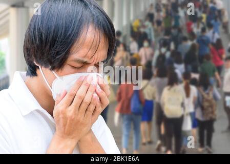 Un uomo asiatico indossa maschera N95 e tosse azione Foto Stock