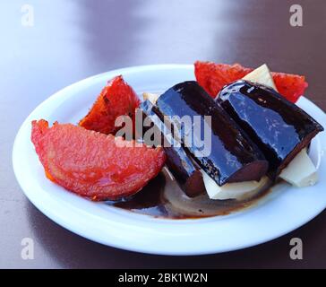 Piatto di insalata di pomodoro alla griglia di melanzane, servita sul tavolo esterno Foto Stock
