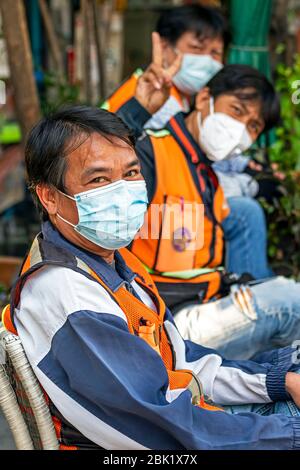 Motociclisti con maschere in attesa per i passeggeri durante la pandemia Covid 19, Bangkok, Thailandia Foto Stock