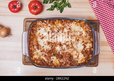 Vista dall'alto di una deliziosa lasagna tradizionale italiana fatta con salsa di bolognese di manzo tritato su tavolo di legno Foto Stock