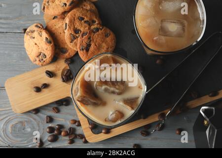 Composizione con caffè ghiaccio e biscotti su sfondo legno Foto Stock