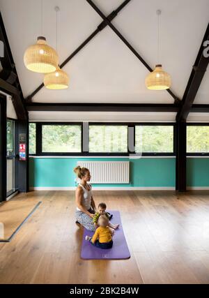 Lezione di pilates di mamme e bambini nello spazio della comunità al piano superiore. Crystal Palace Park Cafe, Crystal Palace, Regno Unito. Architetto: Chris Dyson Architects, Foto Stock