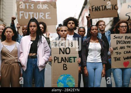 Gruppo di attivisti con striscioni che protestano per salvare la terra. Uomini e donne si ribellano facendo una protesta silenziosa sul riscaldamento globale e l'inquinamento. Foto Stock