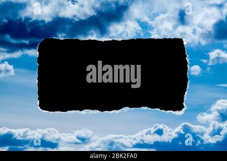 Un buco nel cielo di giorno con i bordi strappati, come sulla carta, con uno sfondo nero copyspace isolato al centro. Il concetto di cambiamento climatico globale in avanti Foto Stock