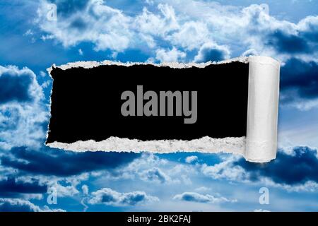 Un buco nel cielo di giorno con i bordi strappati, come sulla carta, con uno sfondo nero copyspace isolato al centro. Il concetto di cambiamento climatico globale in avanti Foto Stock