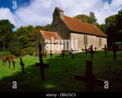 Visita la chiesa di San Davide, la chiesa parrocchiale di Caldey Island, Pembrokeshire, Galles, Regno Unito: Tombe di monaci e isolani segnate da semplici croci di legno. Foto Stock