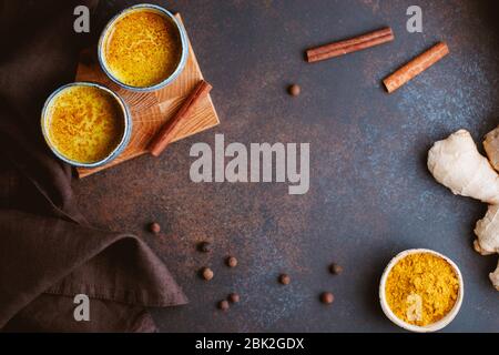 Vista dall'alto del latte curcuma, zenzero, cannella e allspezia. Bevanda immune e sanitaria. Foto Stock
