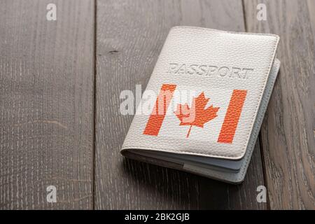 Primo piano su un passaporto canadese su sfondo di legno Foto Stock