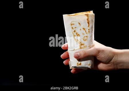 Mano femminile con pita su fondo bianco, fajitas, burrito, shawarma. Foto Stock