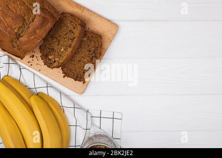 Appena sfornato delizioso pane di banana fatto in casa con noci su tavolo di legno bianco . Disposizione piatta con spazio per la copia Foto Stock