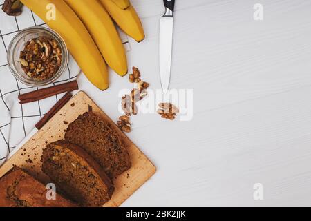 Appena sfornato delizioso pane di banana fatto in casa con noci su tavolo di legno bianco . Disposizione piatta con spazio per la copia Foto Stock