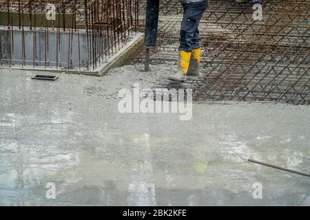 Cantiere, concreting, il soffitto di pavimenti di un edificio è concreted, il calcestruzzo viene da pompa di calcestruzzo sui tappeti di cemento armato, Foto Stock