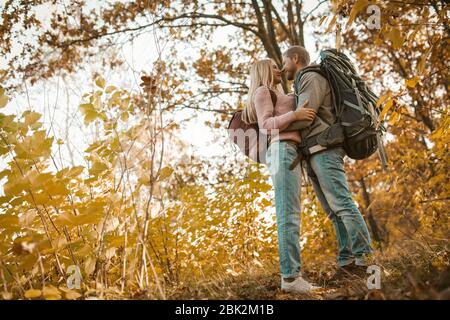 La famiglia dei viaggiatori si fermò in UNA foresta autunnale multicolore Foto Stock