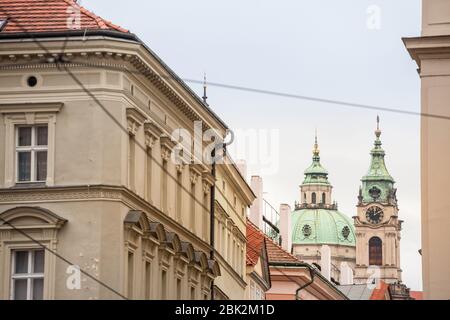 La Chiesa di San Nicola, chiamato anche Kostel Svateho Mikulase, a Praga Repubblica Ceca, con la sua cupola iconica visto da vicino le strade con il barocco tipico Foto Stock