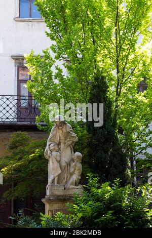 Statua storica in marmo di Sant'Alzbeta Uhroska in un cortile della facoltà teologica nel palazzo Pedostsky, circondata da alberi di primavera. Bratislava, Sl Foto Stock