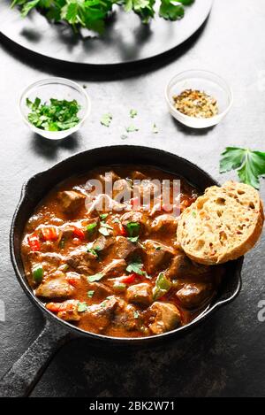 Peri-peri fegati di pollo in padella su fondo di pietra scura. Vista ravvicinata Foto Stock