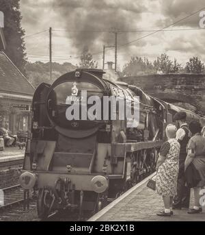 Vista frontale nostalgica e monocromatica del treno a vapore britannico d'epoca che arriva alla stazione di Arley, della Severn Valley Heritage Railway, evento estivo della seconda guerra mondiale degli anni '40. Foto Stock