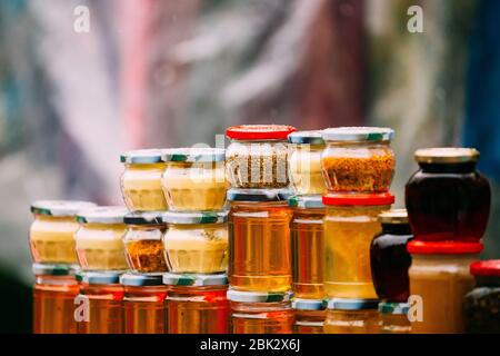 Vari vasi con gustosi dolci Yummy marmellate Stading in righe. Marmellata fatta da noci, pigne, noci, miele. Tradizionale cucina sana Foto Stock