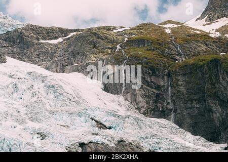 Jostedalsbreen National Park, Norvegia. Vista ravvicinata della fusione del ghiaccio e neve, piccole cascate sul ghiacciaio Boyabreen In estate giornata di sole. Famoso Norwegi Foto Stock
