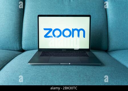Laptop con logo dell'app Zoom Cloud Meetings. Lavoro e riunioni da casa. Foto Stock