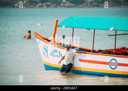 Canacona, Goa, India - 16 febbraio 2020: Uomo che spinge la barca turistica da mare a riva. Foto Stock