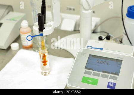 Un chimico conduce uno studio della rigidità della soluzione. Misurazione PH in laboratorio. Un dispositivo per la misurazione chimica del PH. Attrezzature moderne per Foto Stock