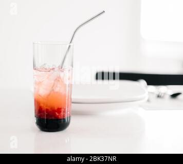 Cena con sfondo bianco e bevanda rossa Foto Stock