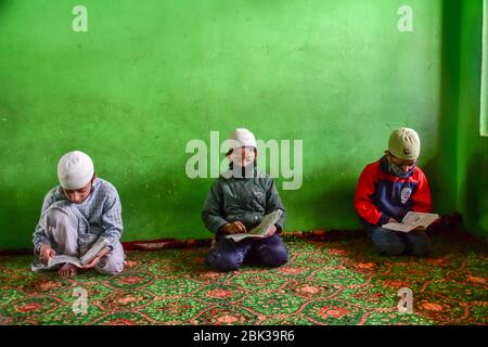 Srinagar, India. 1 maggio 2020. I bambini Kashmiri indossano maschere facciali protettive mentre recitano i versetti del Corano in un orfanotrofio durante il mese santo del Ramadan. I musulmani di tutto il mondo stanno segnando il mese del Ramadan e hanno trovato modi diversi per celebrare il Ramadan quest'anno, poiché le restrizioni imposte dai paesi per frenare la diffusione del coronavirus hanno chiuso le moschee e vietato le riunioni. Ramadan è il mese più sacro del calendario islamico in cui i devoti digiunano dall'alba al tramonto. Credit: SOPA Images Limited/Alamy Live News Foto Stock