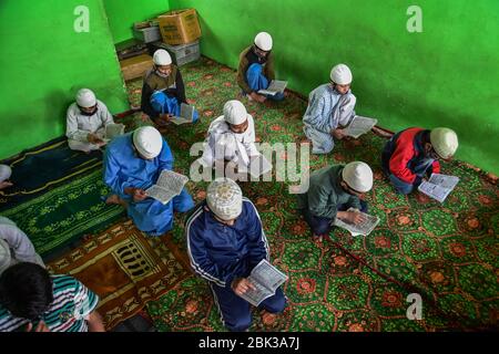 Kashmir, Jammu & Kashmir, India. 1° maggio 2020. I bambini Kashmiri indossano maschere facciali protettive mentre recitano versetti dal Corano in un orfanotrofio in mezzo alla chiusura durante il mese santo del Ramadan.Musulmani in tutto il mondo stanno segnando il mese del Ramadan e hanno trovato modi diversi per celebrare il Ramadan quest'anno, come le restrizioni imposte dai paesi per frenare la diffusione del coronavirus hanno chiuso le moschee e vietato le riunioni. Ramadan è il mese più sacro del calendario islamico in cui i devoti digiunano dall'alba al tramonto. Credit: Saqib Majeed/SOPA Images/ZUMA Wire/Alamy Live News Foto Stock