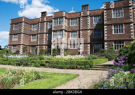 Doddington Hall giardini formali con rose arbustive; iride e allari alti Foto Stock