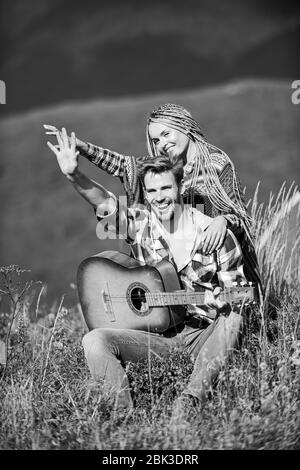 Aria fresca e sentimenti puri. Ragazzo e ragazza con la chitarra. Escursionismo romance. Passeggiata romantica. Canzone romantica. L'amore li ispira. Bella coppia romantica felice volti sorridenti sullo sfondo della natura. Foto Stock