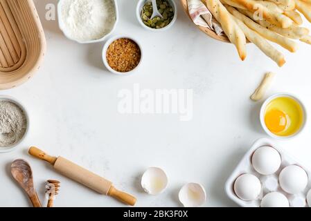 Cucina casalinga - cottura di pane fresco o torte da ingredienti naturali organici farina di grano e segale, uova, zucchero di canna e semi di zucca su una luce Foto Stock