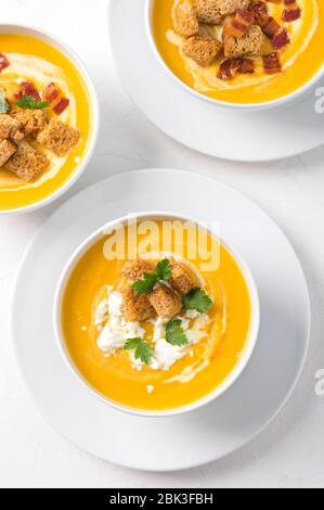 Zuppa di panna di zucca con crema di latte, pancetta, crostini, formaggio feta e prezzemolo. Vista dall'alto Foto Stock