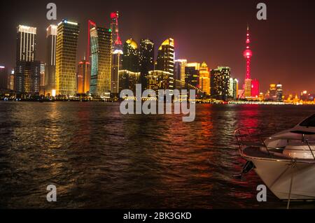 Illuminato sullo skyline di Pudong visto dietro Xin da Tang, uno yacht ormeggiato sul North Bund parte di Shanghai. Foto Stock