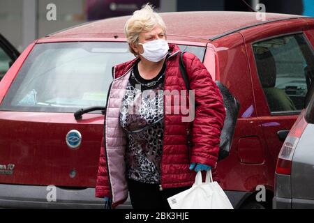 Belgrado, Serbia. 30 Aprile 2020. Una donna con maschere e guanti torna dallo shopping dopo la riapertura di parrucchieri, palestre, mercati e parchi durante la malattia di coronavirus (COVID-19). Il presidente Aleksandar Vucic aveva dichiarato lo stato di emergenza per fermare la diffusione del coronavirus. Anche il governo ha vietato a tutti i 65 anni di lasciare le loro case. A seguito del calo del numero di pazienti coronavirus il governo di questa settimana permette la riapertura di parrucchieri, palestre, mercati e parchi.Credit: Nikola Krstic/Alamy Live News Foto Stock