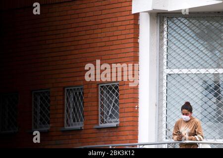 Belgrado, Serbia. 30 Aprile 2020. Una giovane donna con maschera usa il suo cellulare mentre attende in linea dopo la riapertura di parrucchieri, palestre, mercati e parchi durante la malattia di coronavirus (COVID-19). Il presidente Aleksandar Vucic aveva dichiarato lo stato di emergenza per fermare la diffusione del coronavirus. Anche il governo ha vietato a tutti i 65 anni di lasciare le loro case. A seguito del calo del numero di pazienti coronavirus il governo di questa settimana permette la riapertura di parrucchieri, palestre, mercati e parchi.Credit: Nikola Krstic/Alamy Live News Foto Stock