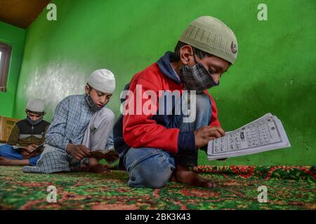 Kashmir, Jammu & Kashmir, India. 1° maggio 2020. I bambini Kashmiri indossano maschere facciali protettive mentre recitano i versetti del Corano in un orfanotrofio durante il mese santo del Ramadan. I musulmani di tutto il mondo stanno segnando il mese del Ramadan e hanno trovato modi diversi per celebrare il Ramadan quest'anno, poiché le restrizioni imposte dai paesi per frenare la diffusione del coronavirus hanno chiuso le moschee e vietato le riunioni. Ramadan è il mese più sacro del calendario islamico in cui i devoti digiunano dall'alba al tramonto. Credit: Saqib Majeed/SOPA Images/ZUMA Wire/Alamy Live News Foto Stock