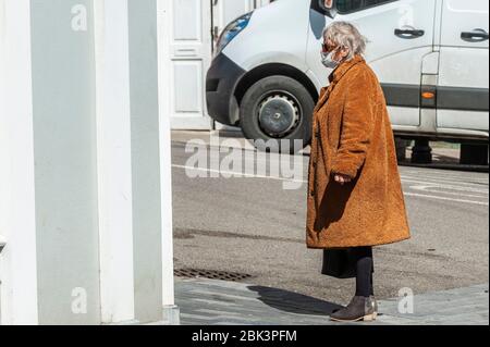 Clonakilty, West Cork, Irlanda. 1° maggio 2020. Una donna che indossa una maschera facciale per proteggersi dalle code di Coronavirus Covid-19 fuori da una farmacia in Clonakilty Main Street. Credit: AG News/Alamy Live News. Foto Stock