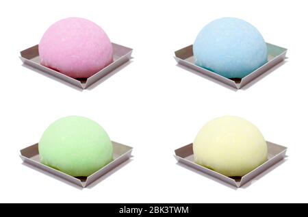 Un set di quattro mochi colorati isolati su sfondo bianco. Limone giallo mochi, tè verde mochi, mirtillo blu mochi, lampone viola mochi Foto Stock