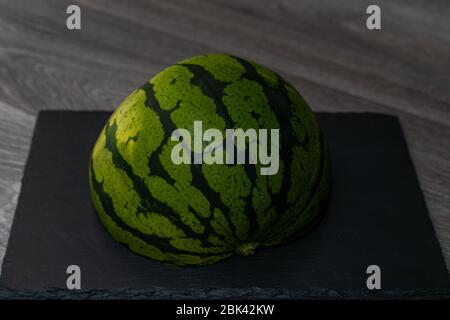 L'anguria matura si trova su un asse di legno Foto Stock