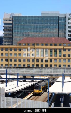 Vista sulle piattaforme 6 e 7 alla stazione ferroviaria di Wellington con treni elettrici il 30 novembre 2017 e agli alti edifici oltre il capolinea Foto Stock