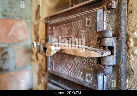 Porta in metallo con un segno di spunta per la vecchia stufa in maiolica Foto Stock