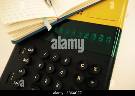 Vecchio modello di computer degli anni '80 su sfondo bianco, è acceso scrive 2020 e un notebook con una penna pronta per le note. Foto Stock
