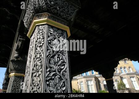 Vicino di colonne di legno intagliate sulla porta di Jaipur nei terreni del Museo di Hove, Hove, Sussex orientale. L'edificio del Museo è visibile sullo sfondo. Foto Stock