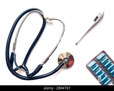 Termometro elettronico, tonometro e pillole su sfondo bianco.Medicina e salute Concept.Medical modello. Foto Stock