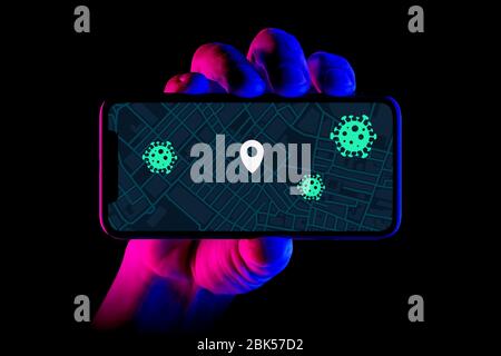 Uno smartphone che visualizza l'applicazione di tracciamento dei contatti di Covid-19 in uso viene tenuto da un colpo manuale su sfondo nero (solo per uso editoriale). Foto Stock