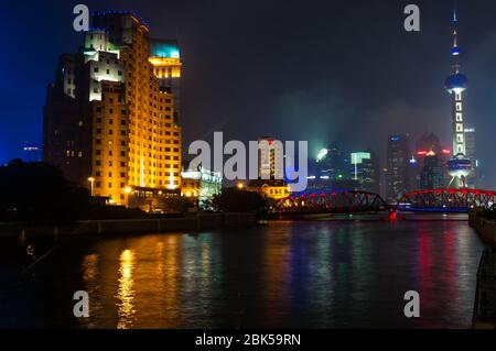 Una vista serale di Suzhou Creek che mostra il Broadway Mansions Hotel e il giardino ponte lungo con la Oriental Pearl Tower a Pudong al di là. Shanghai, Foto Stock