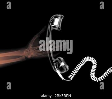 Mano umana e telefono, radiografia colorata. Foto Stock