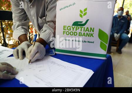 Pechino, Cina. 2 maggio 2020. La gente aspetta di ricevere cibo distribuito dall'organizzazione no-profit Egyptian Food Bank (EFB) al Cairo, Egitto, 15 aprile 2020. Una campagna chiamata "giorno del lavoro di supporto, una responsabilità sociale" è stata lanciata dall'EFB ed è intesa a distribuire 500,000 scatole di cibo ai lavoratori di giorno che sono stati duramente colpiti dalle recenti misure preventive adottate dal governo egiziano per combattere la diffusione del romanzo coronavirus. Credit: Ahmed Gomaa/Xinhua/Alamy Live News Foto Stock