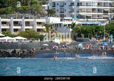 Vista panoramica verso la famosa spiaggia di Arana con sabbia vulcanogena nera a Puerto de Santiago dall'acqua, Tenerife, Isole Canarie, Spagna. Foto Stock